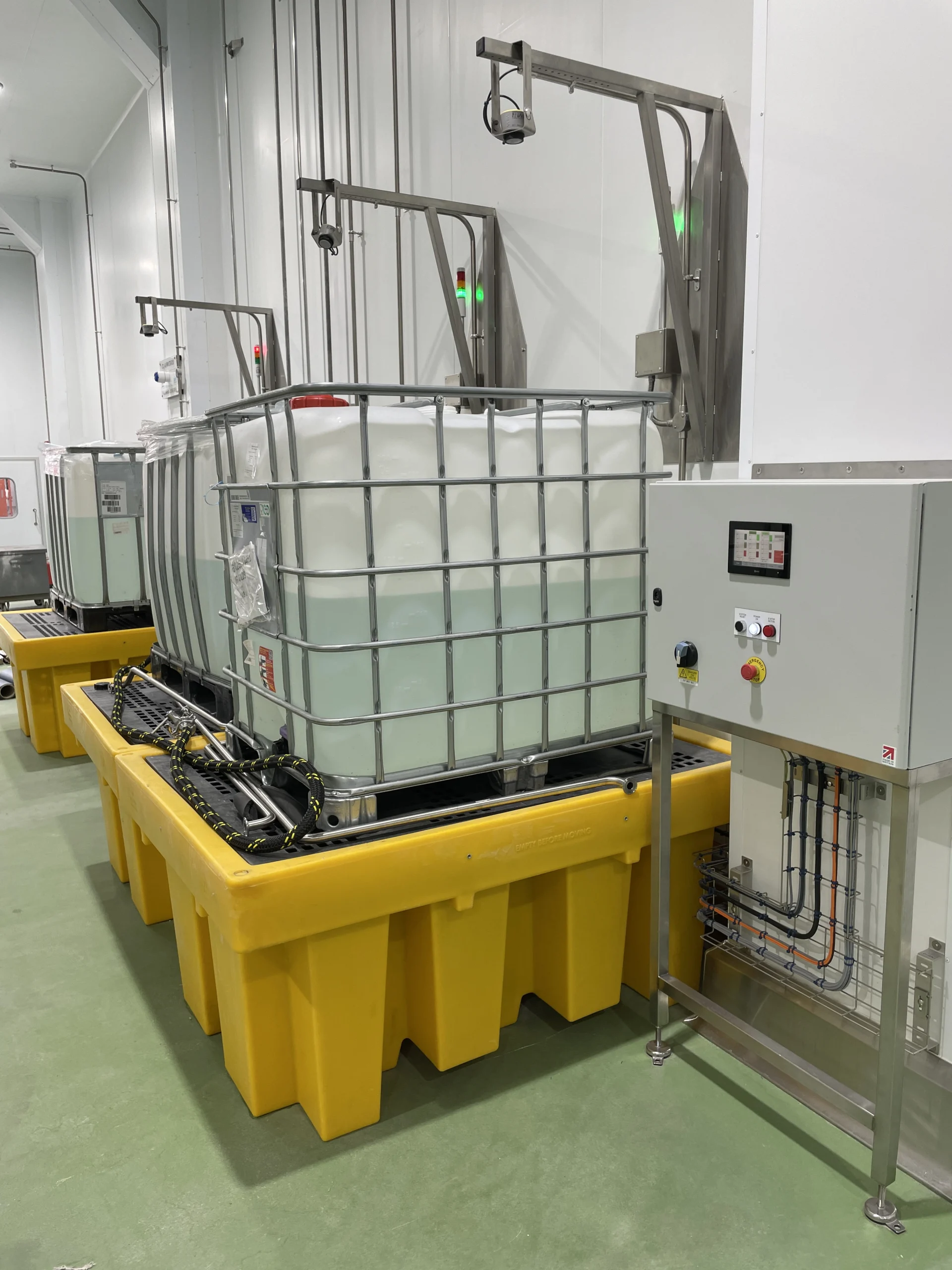 IBC decanting system with an automated control panel in a facility