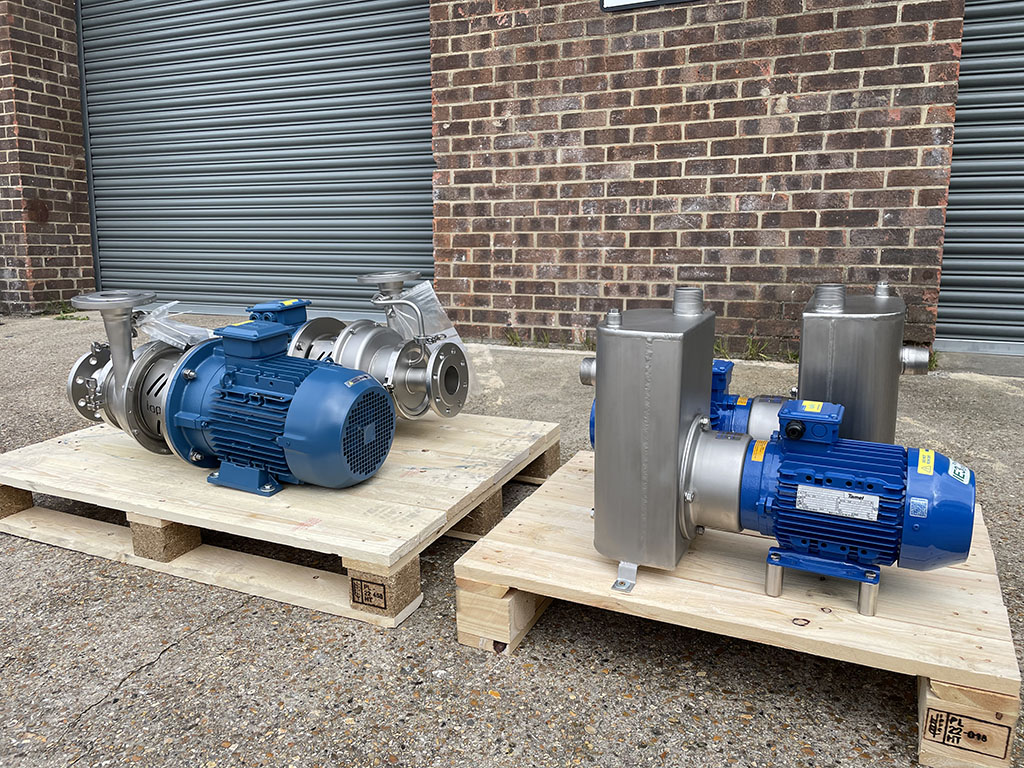 A picture of 4 self priming centrifugal pumps on a crate in front of a warehouse building ready to be shipped to a client